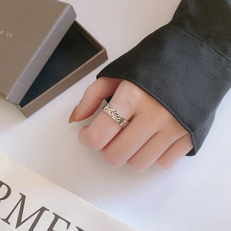 Black copper geometric adjustable ring with round and oval shapes on a white background