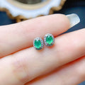 Natural emerald stud earrings in S925 silver with inlaid green main stone on white background