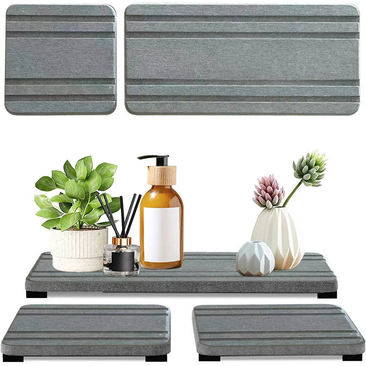 Set of three square diatom oil water draining pads in dark gray, light gray, and white on a bathroom countertop