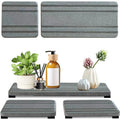 Set of three square diatom oil water draining pads in dark gray, light gray, and white on a bathroom countertop