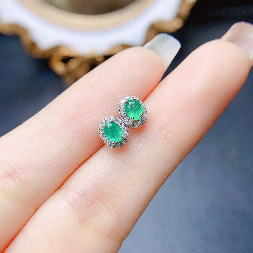 Natural emerald stud earrings in S925 silver with inlaid green main stone on white background