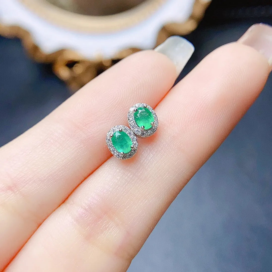 Natural emerald stud earrings in S925 silver with inlaid green main stone on white background