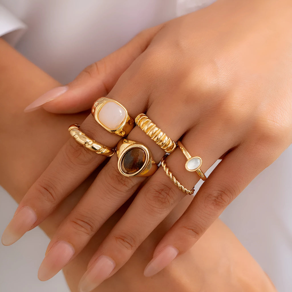Six light gold alloy rings with irregular geometric shape, electroplated finish, on display