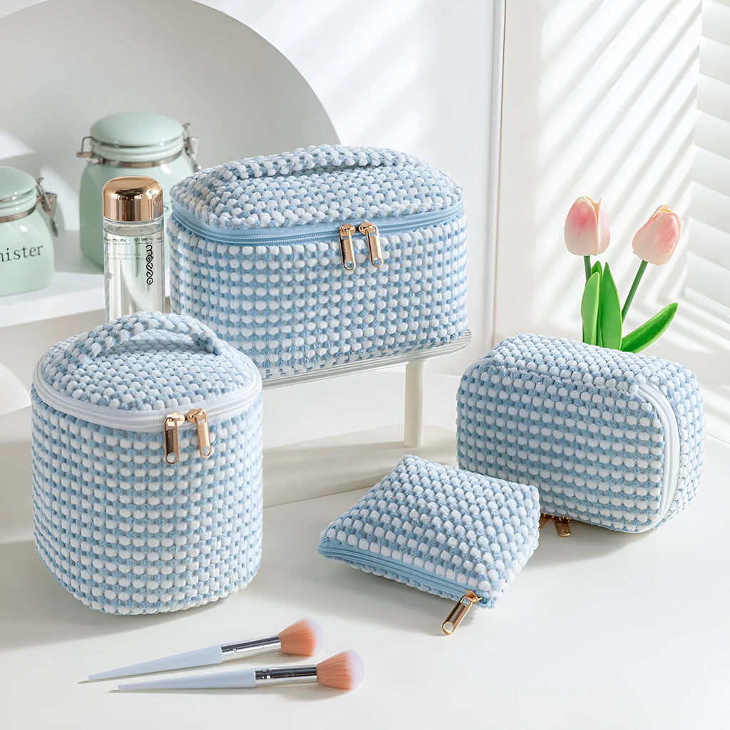 Four cube-shaped makeup bags in matching colour sets for travel cosmetic organisation