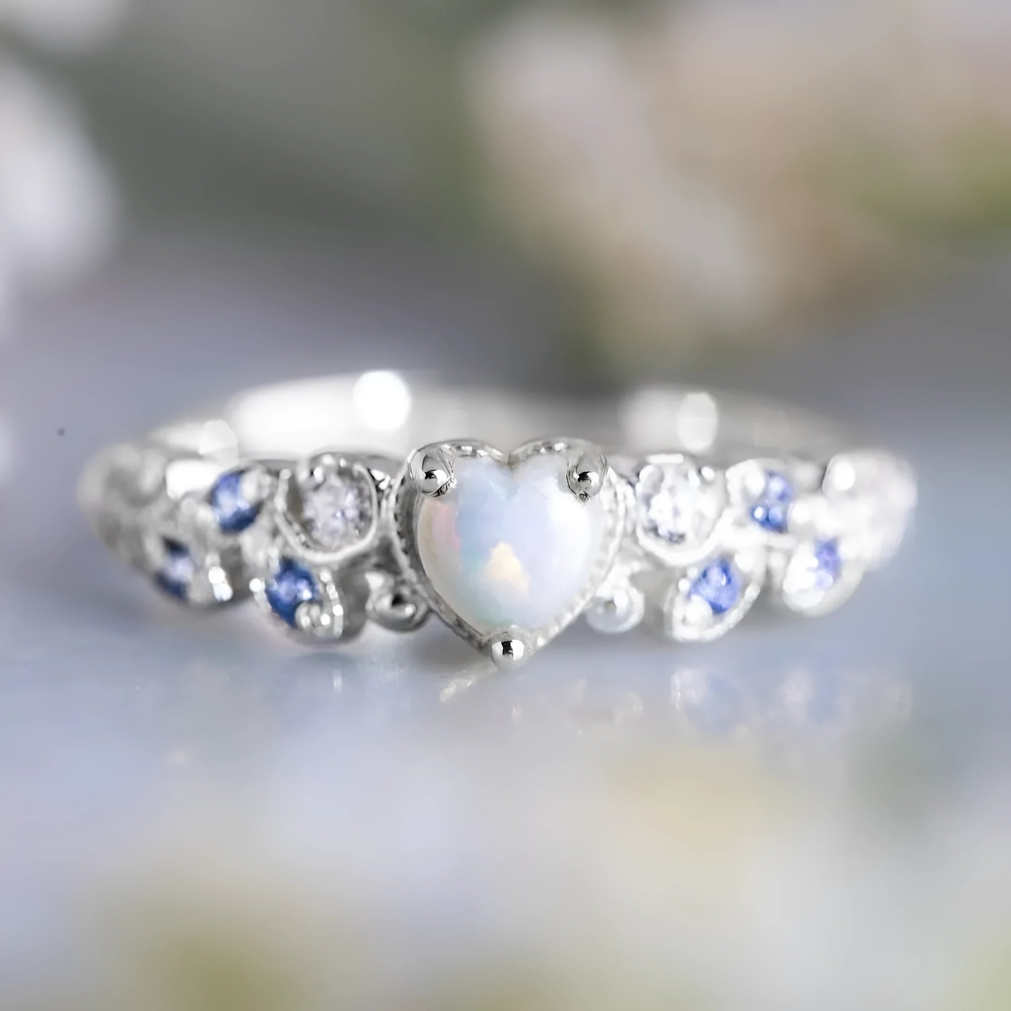 White alloy women's ring with a heart shape, floral detailing, and opalescent peach ocean design.