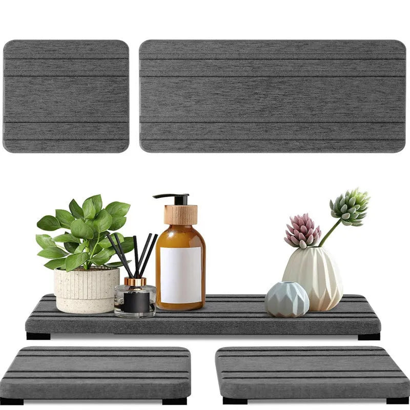 Set of three square diatom oil water draining pads in dark gray, light gray, and white on a bathroom countertop