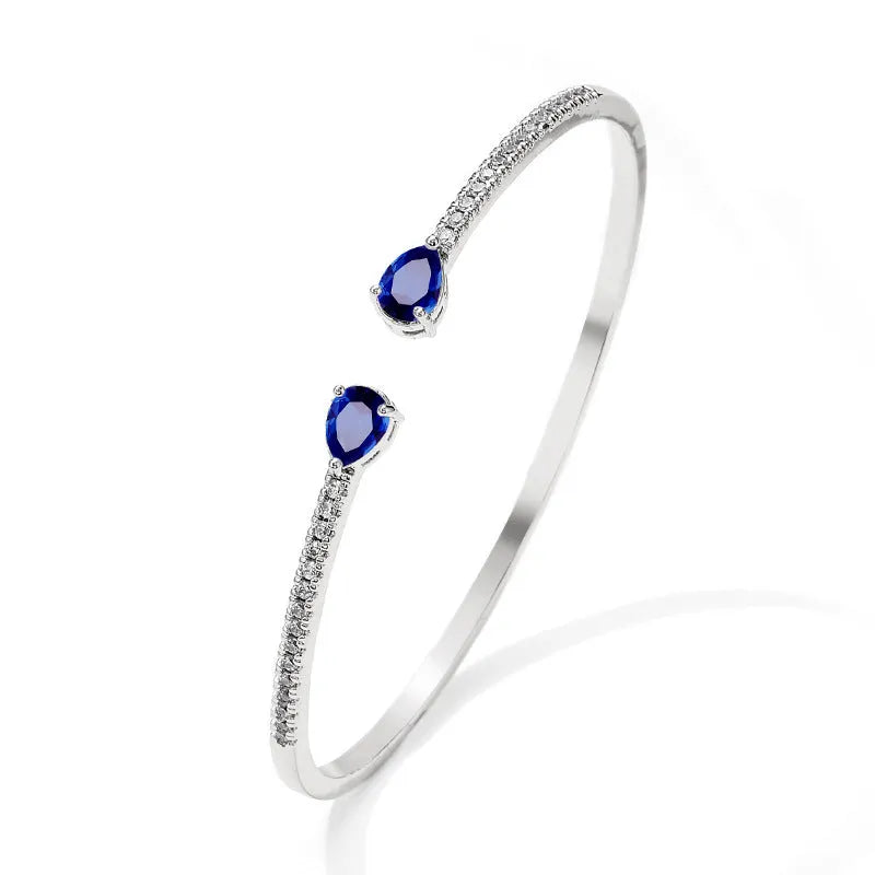 Copper bracelet with inlaid zircon stones in a simple style, shown in white and blue colour options.