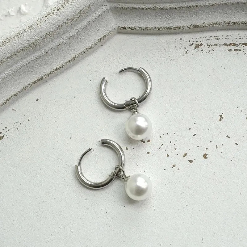 Geometric pearl drop earrings with round elements made from titanium steel alloy