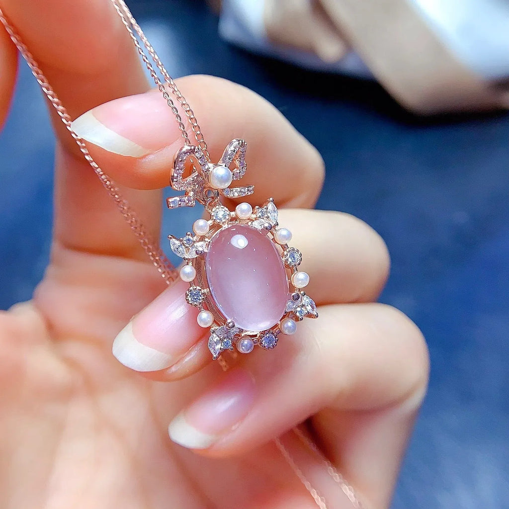 Geometric silver alloy pendant with pink rose quartz crystal and rose gold plating on a chain.