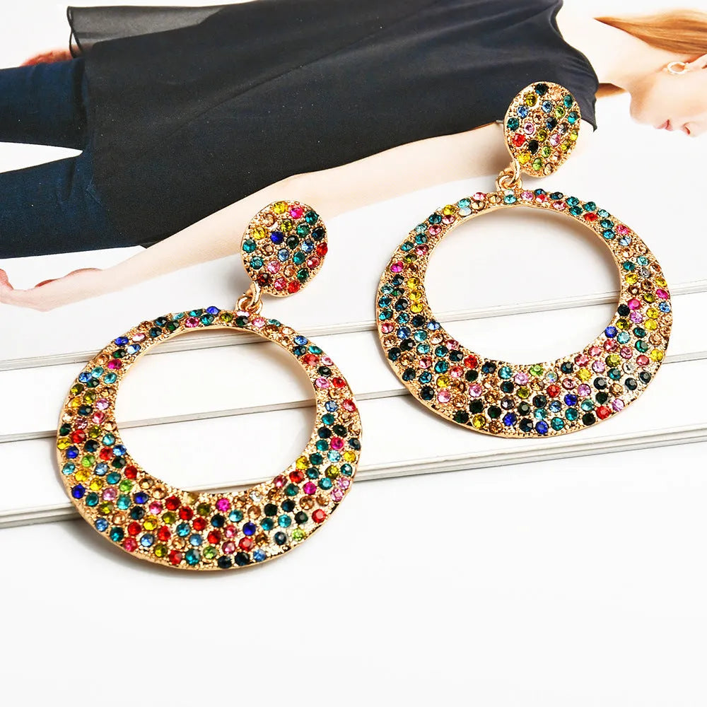 A pair of large round colourful alloy pendant earrings with a cartoon style on a white background.