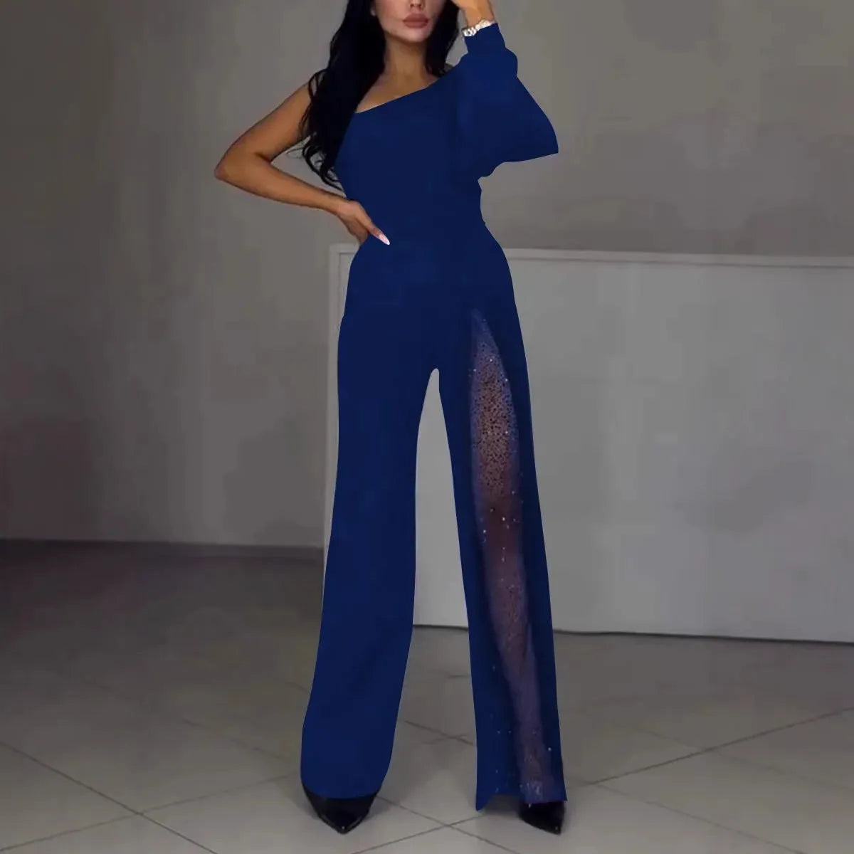Women's black oblique shoulder jumpsuit with high slit and long sleeves.