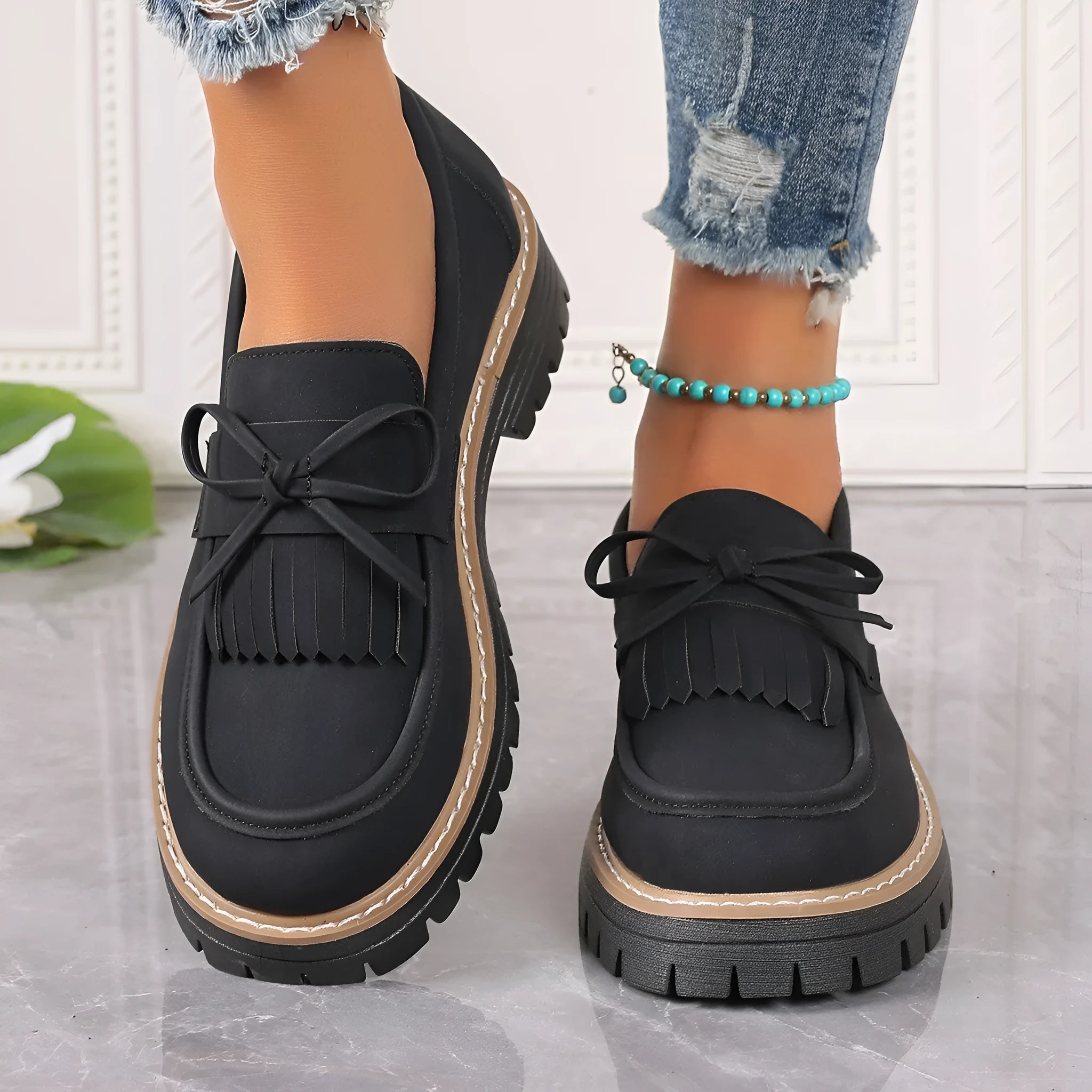 Black plus size women's loafer with tassel decoration and a bowknot on a low chunky heel.