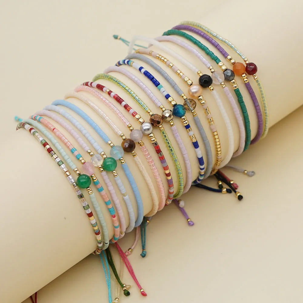 Handmade colourful glass beaded bracelet in geometric Bohemian style on a female wrist.