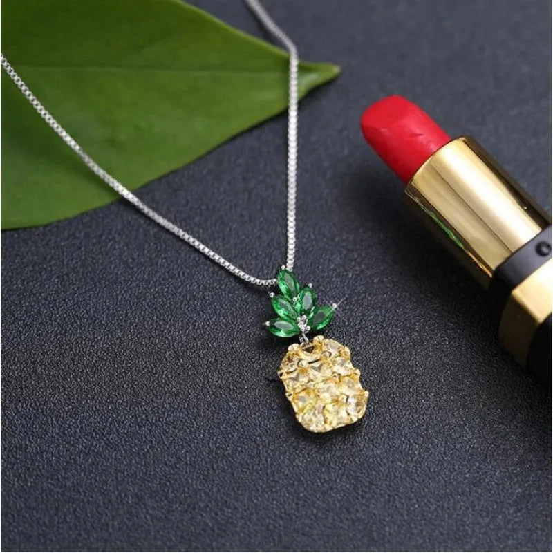 Silver women's necklace with a geometric pineapple and diamond design pendant on a chain.