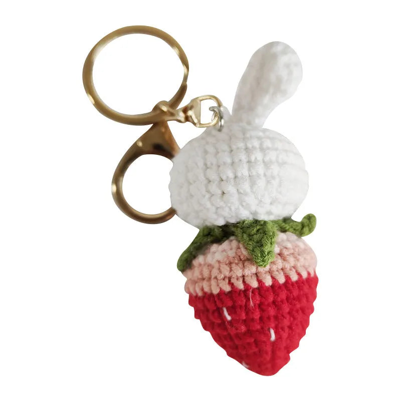 White hand-woven wire pendant with rabbit and strawberry design on a key fitting.