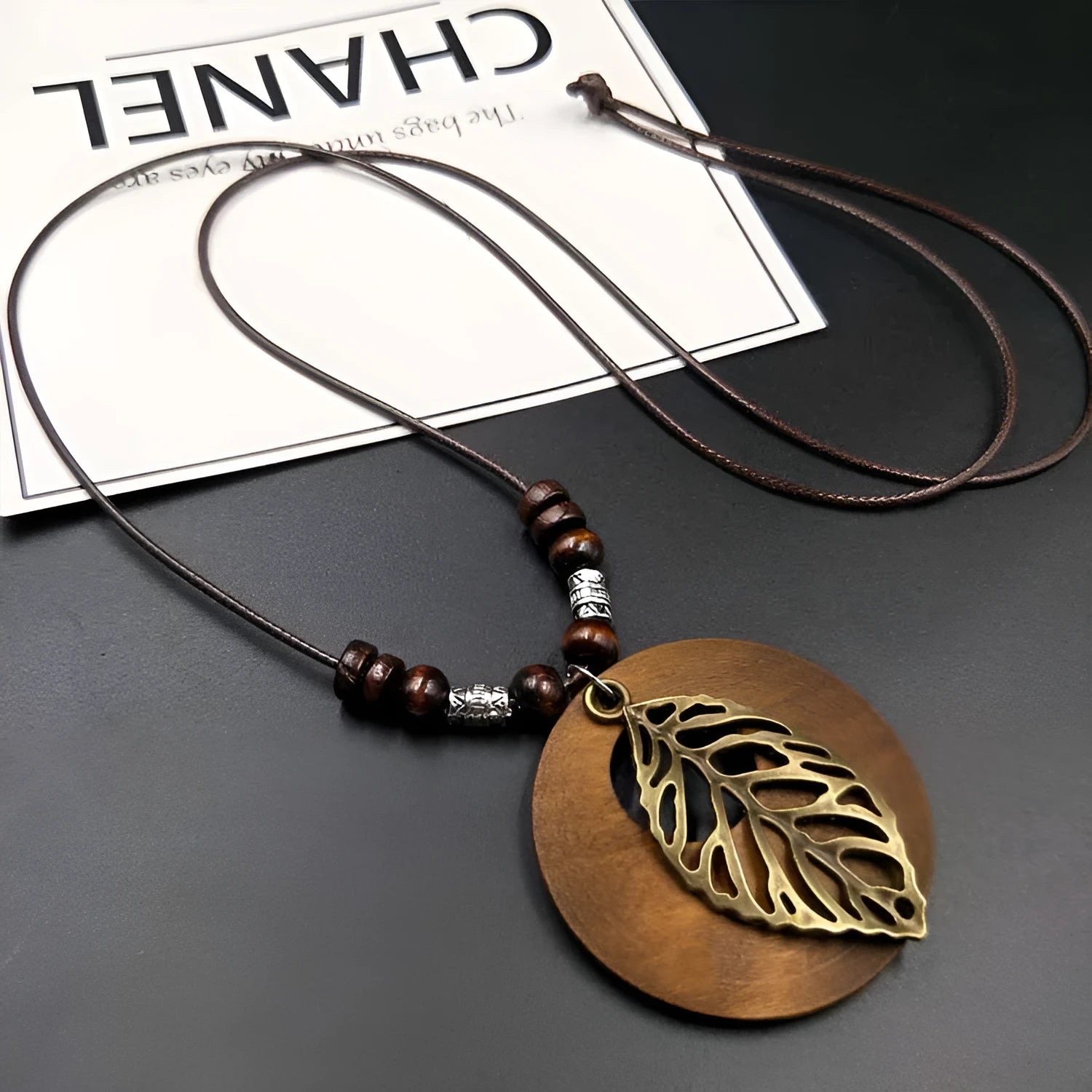 Wooden leaf pendant necklace with ethnic design featuring cotton and linen materials on wax line chain