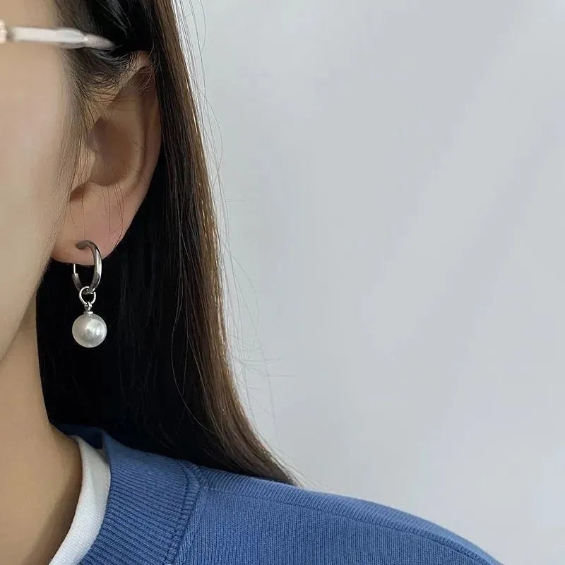 Geometric pearl drop earrings with round elements made from titanium steel alloy