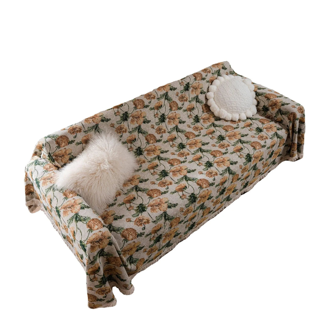 American country style jacquard patterned sofa cover in a green colourway draped over a sofa.