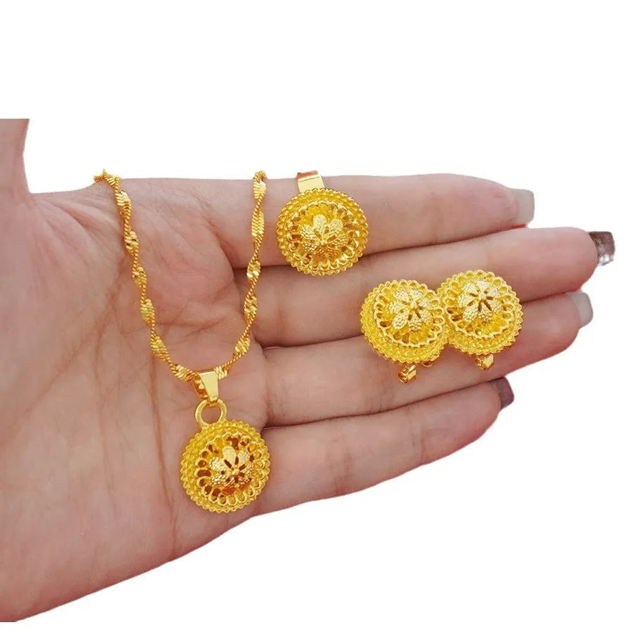 Landscape Middle East gold-plated three-piece jewellery set showing necklace, earrings, and ring with layered floral design.