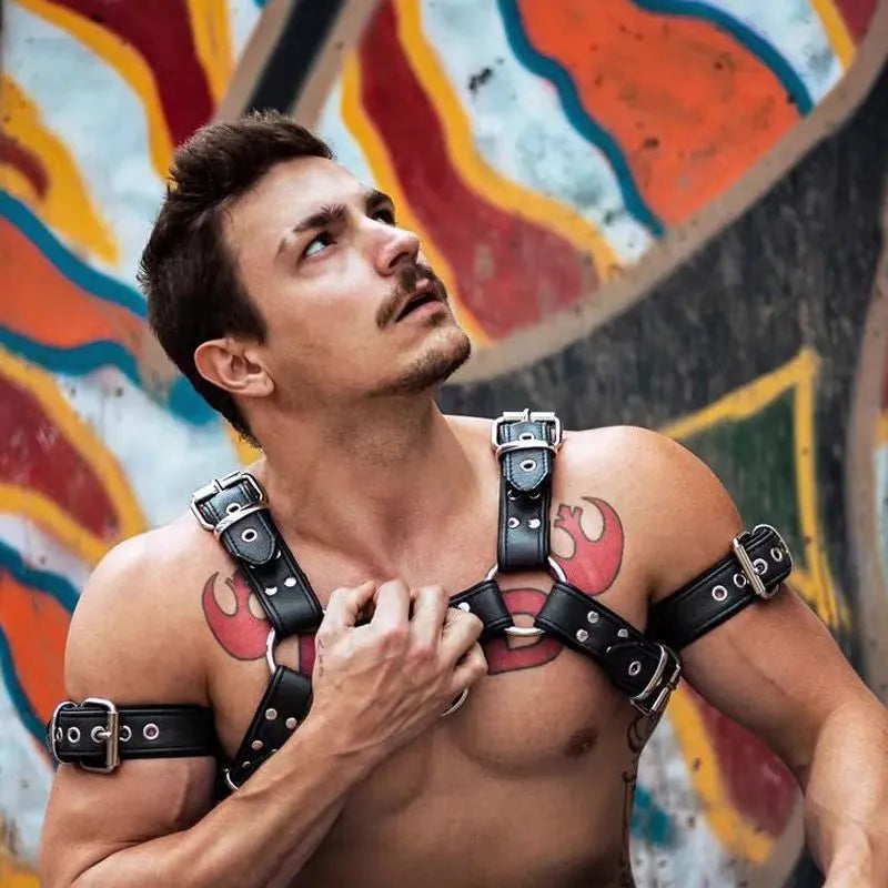 Black leather chest harness strap with metal buckles for men's bondage costume.