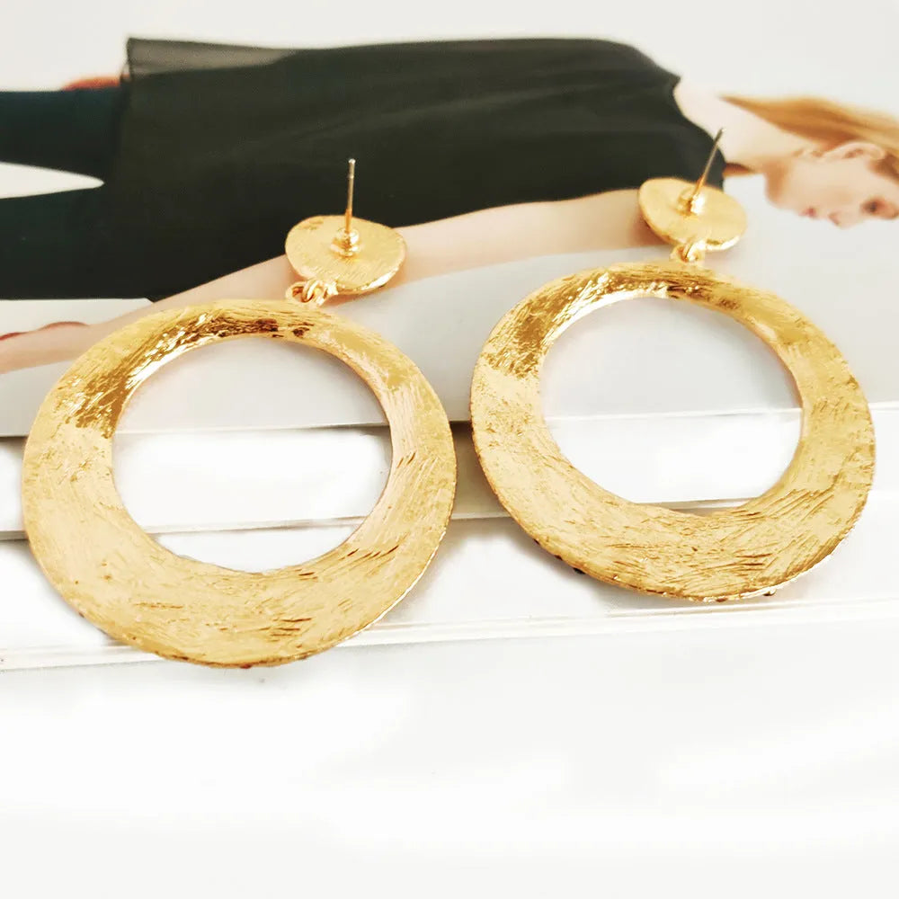 A pair of large round colourful alloy pendant earrings with a cartoon style on a white background.