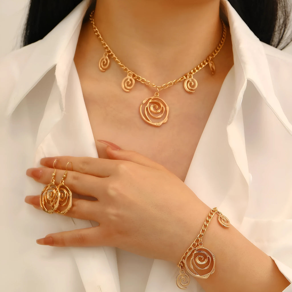 Gold spiral donut necklace, bracelet, and ear hooks set for women on a plain background.