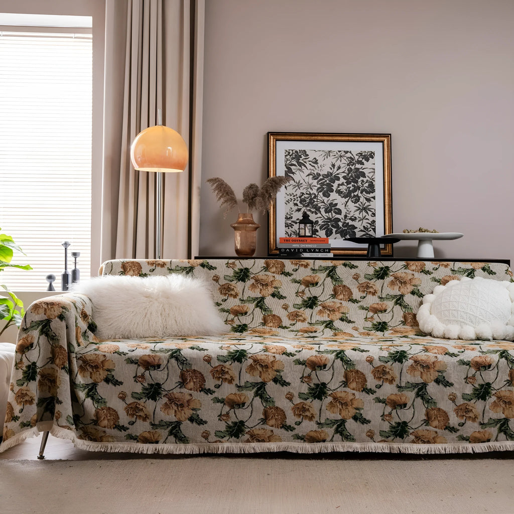 American country style jacquard patterned sofa cover in a green colourway draped over a sofa.