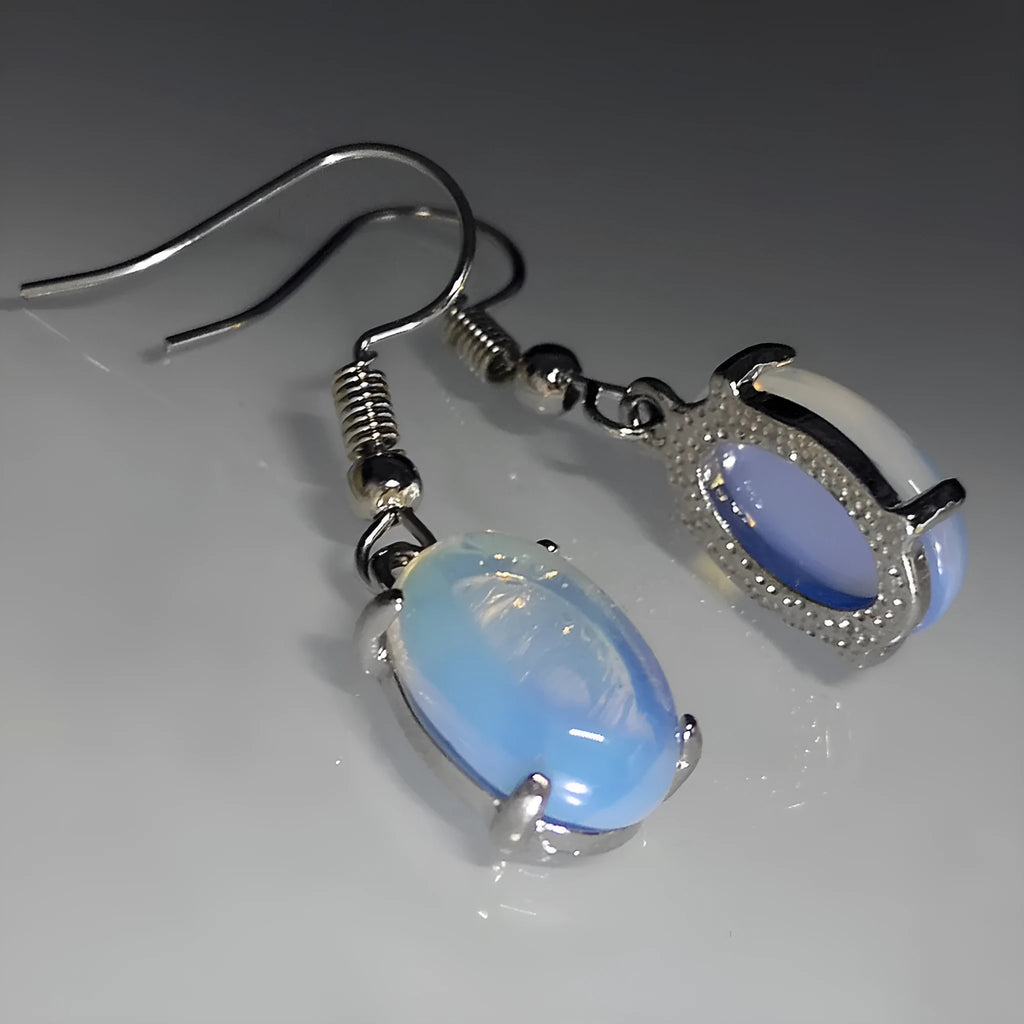 A pair of retro opal earrings with a moonstone eardrop and cross design in electroplated alloy.