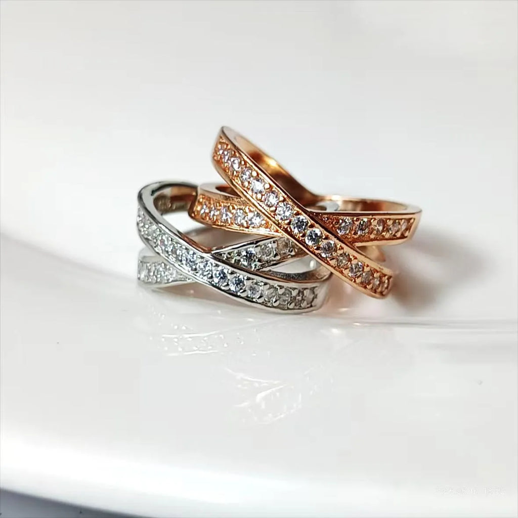 Copper metal cross ring with micro-inlaid zircon stones in silver electroplated finish showing geometric heart-shaped design