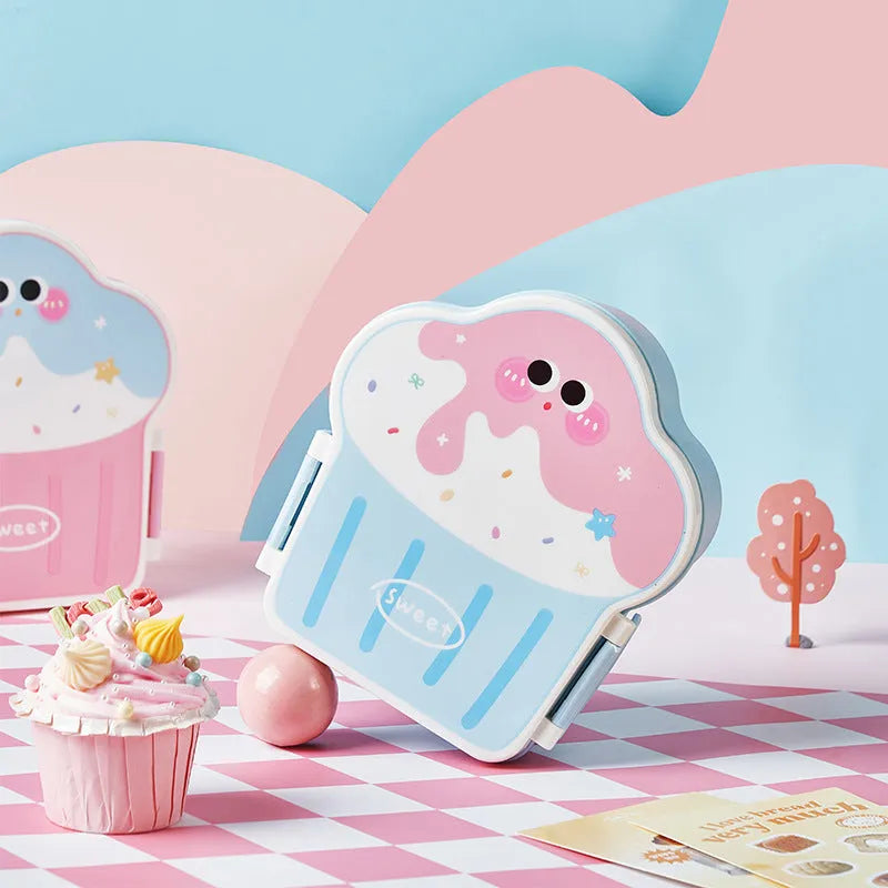 Pink and blue creative ice cream shaped plastic lunch box with spoon and fork set on a table.