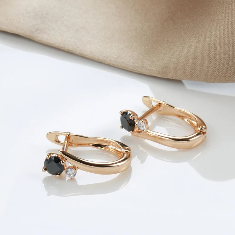 Gold coloured drop earrings with black agate stone centre and geometric design on copper settings