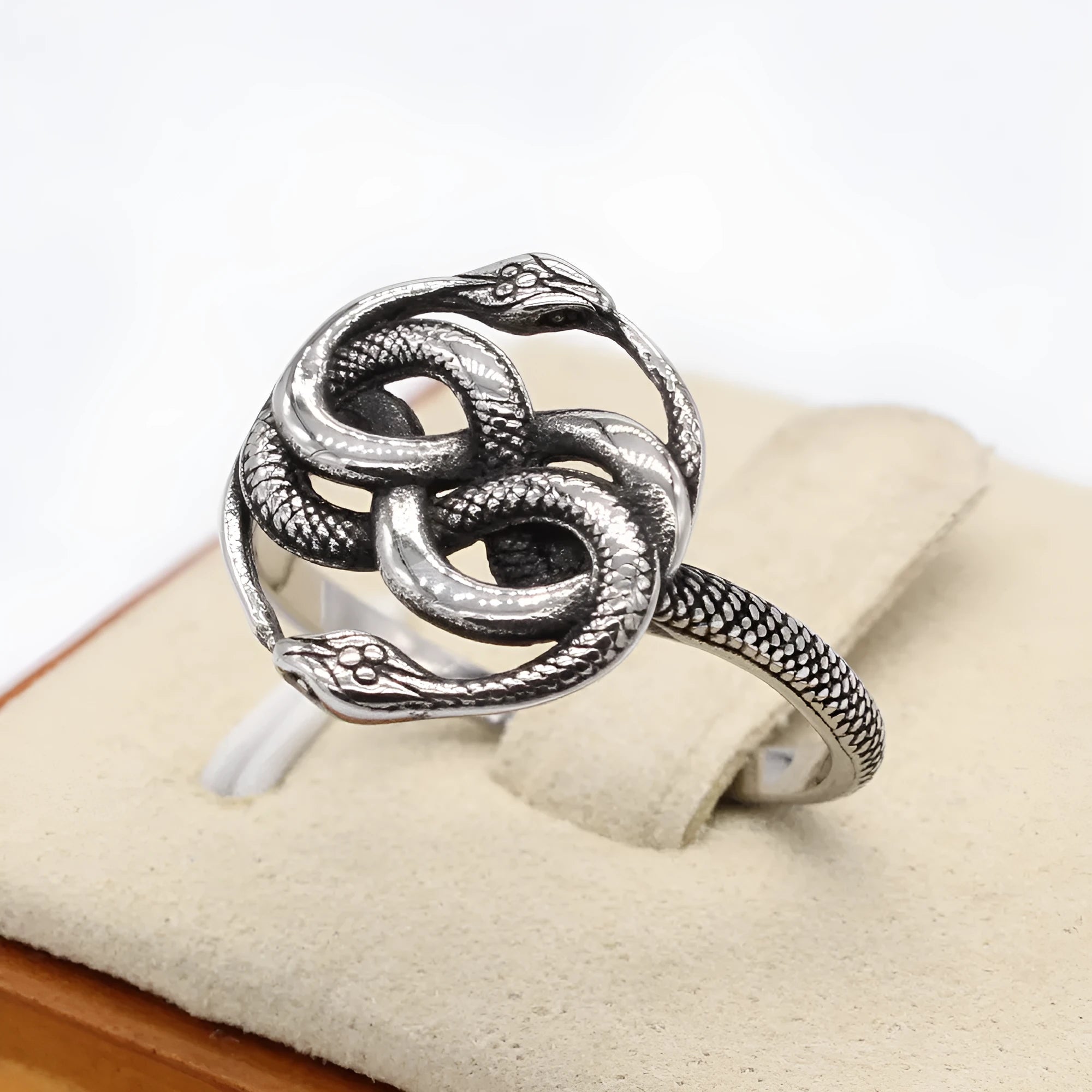 Steel colour titanium steel double snake ring on a finger, showing retro design.