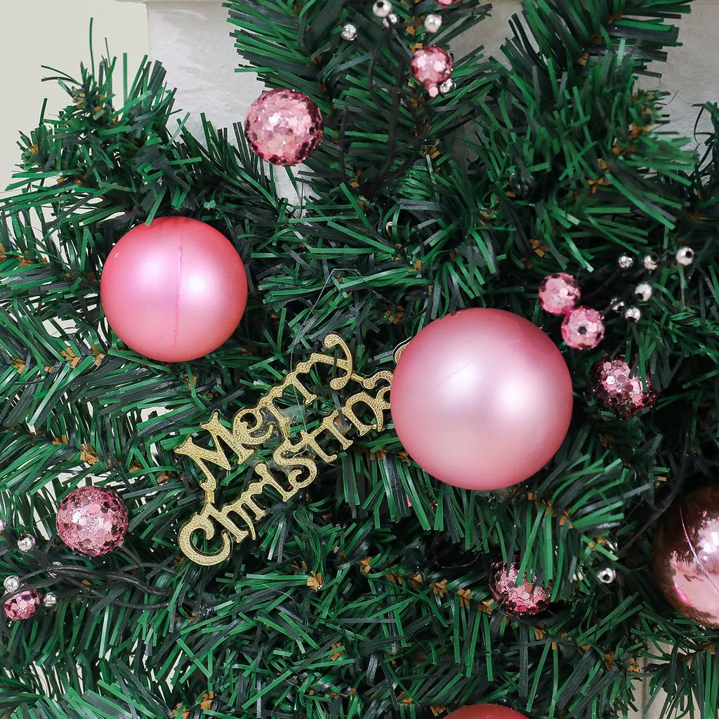 Pink Christmas rattan vine garland draped in a loop, showing small fruit details and LED lights.