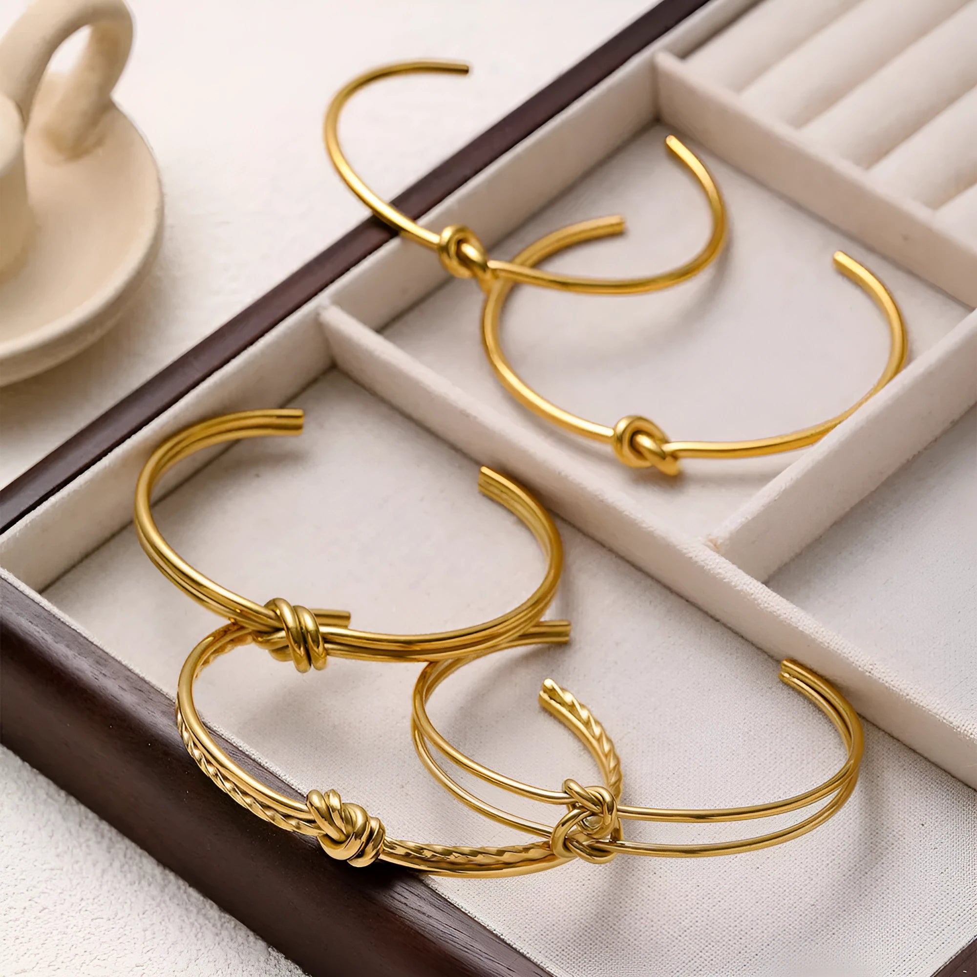 Stainless steel 18K gold plated knotted open double-layer bracelet in gold (SZ46G) on a white background
