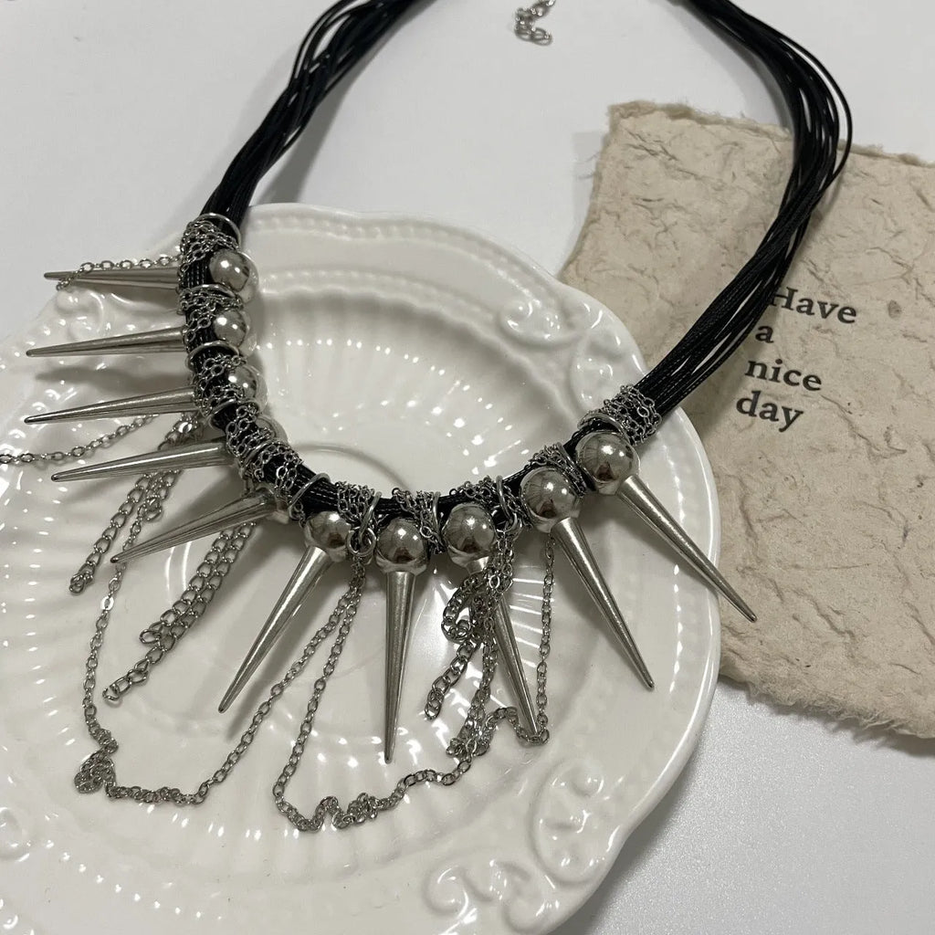 Leather necklace with round beads and winding tassel featuring rivet details in picture colour