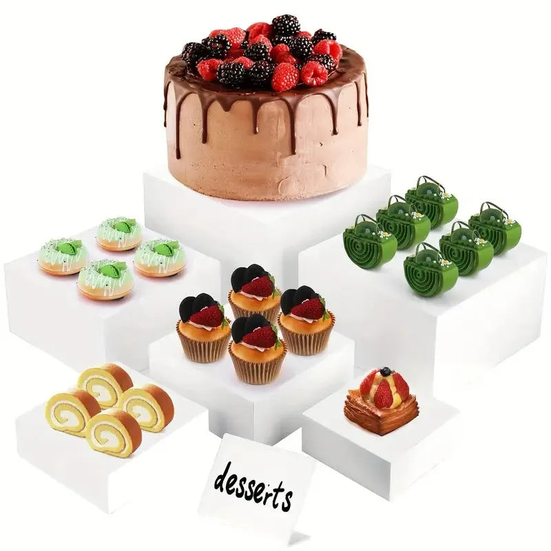 White and clear plastic modular six-piece suit cube dessert display stand on a desktop.
