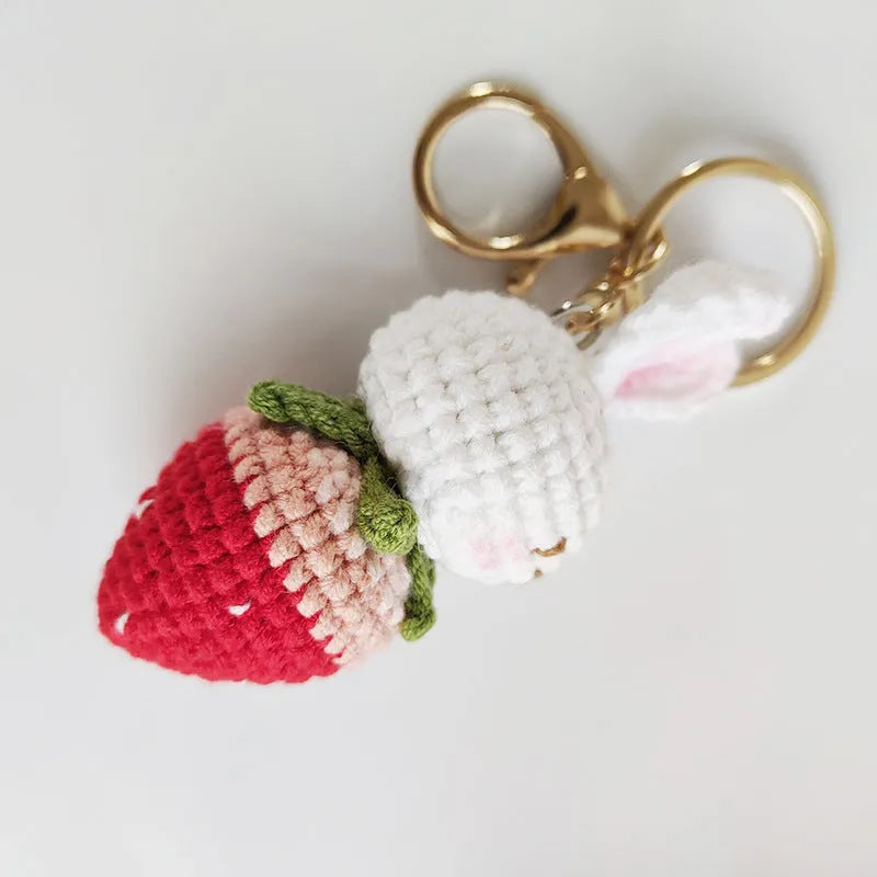 White hand-woven wire pendant with rabbit and strawberry design on a key fitting.