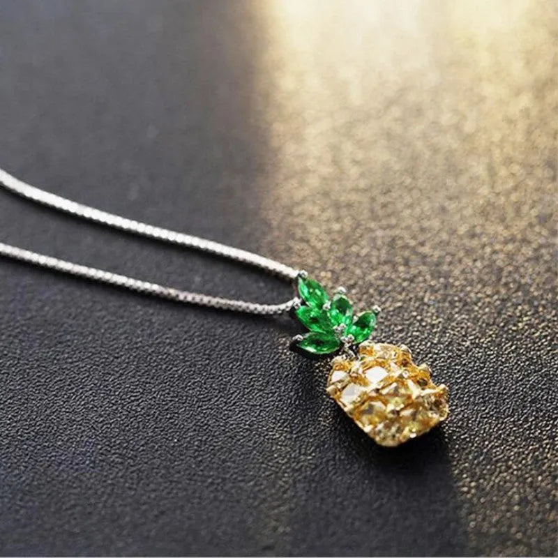 Silver women's necklace with a geometric pineapple and diamond design pendant on a chain.