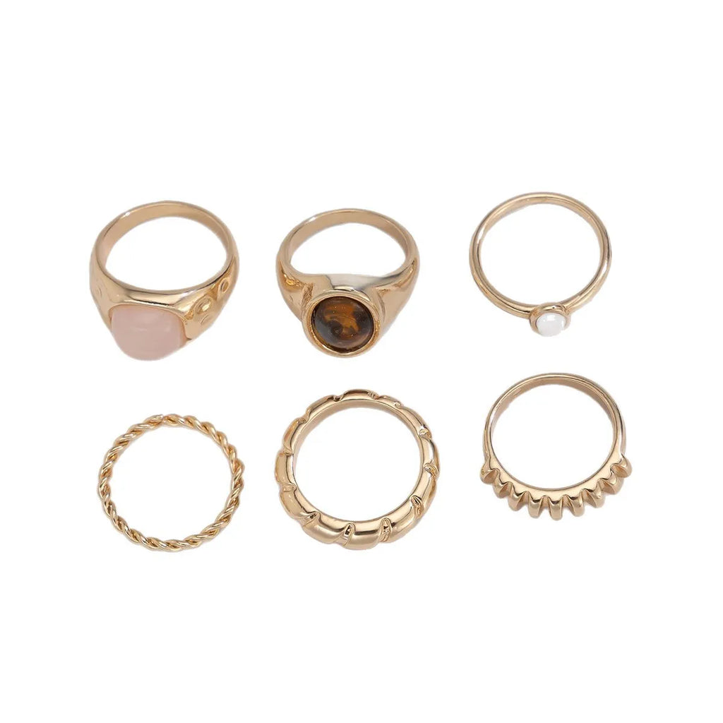 Six light gold alloy rings with irregular geometric shape, electroplated finish, on display