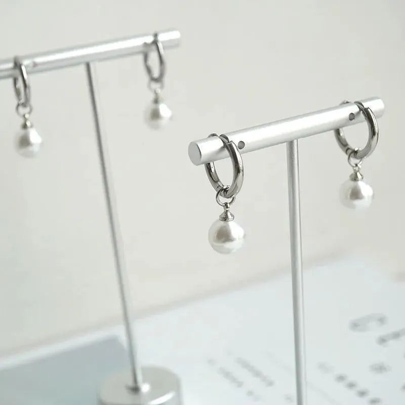 Geometric pearl drop earrings with round elements made from titanium steel alloy
