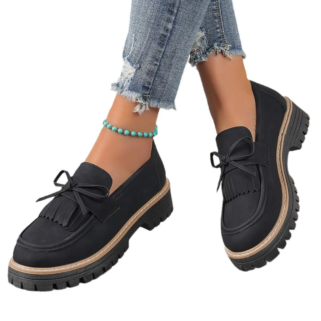 Black plus size women's loafer with tassel decoration and a bowknot on a low chunky heel.