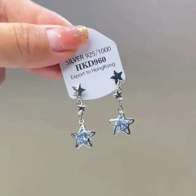 Geometric alloy ear clip with a heart rhinestone and dangling tassel, showing both stud and clip-on back options.