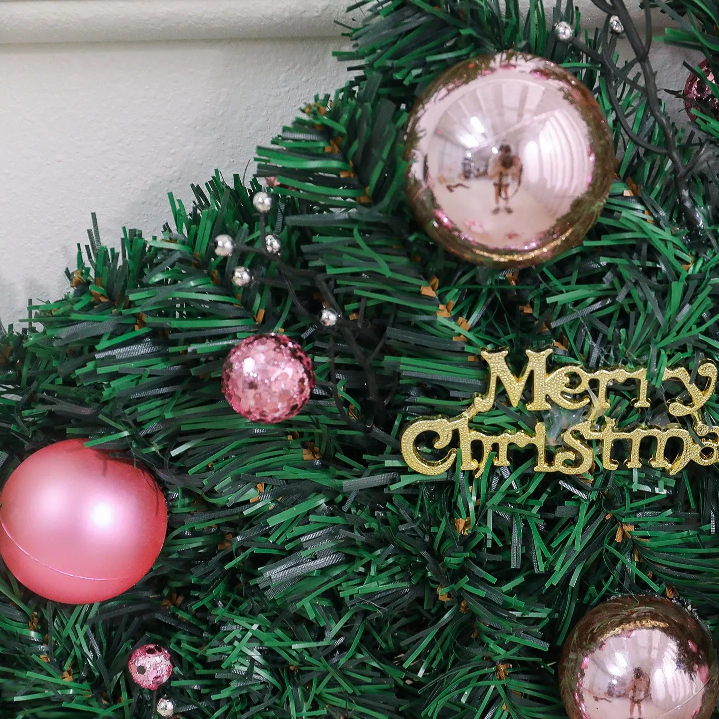 Pink Christmas rattan vine garland draped in a loop, showing small fruit details and LED lights.