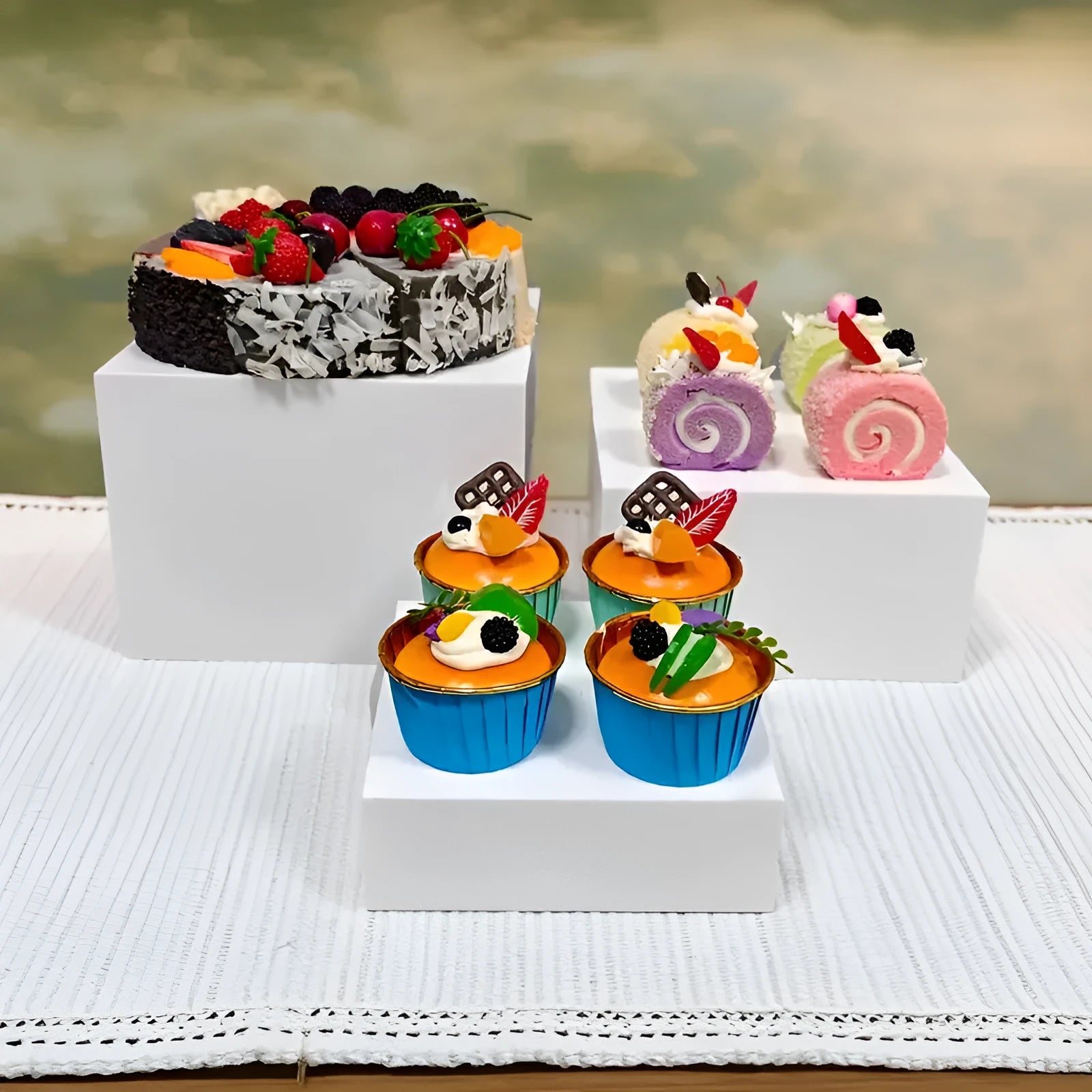 White and clear plastic modular six-piece suit cube dessert display stand on a desktop.
