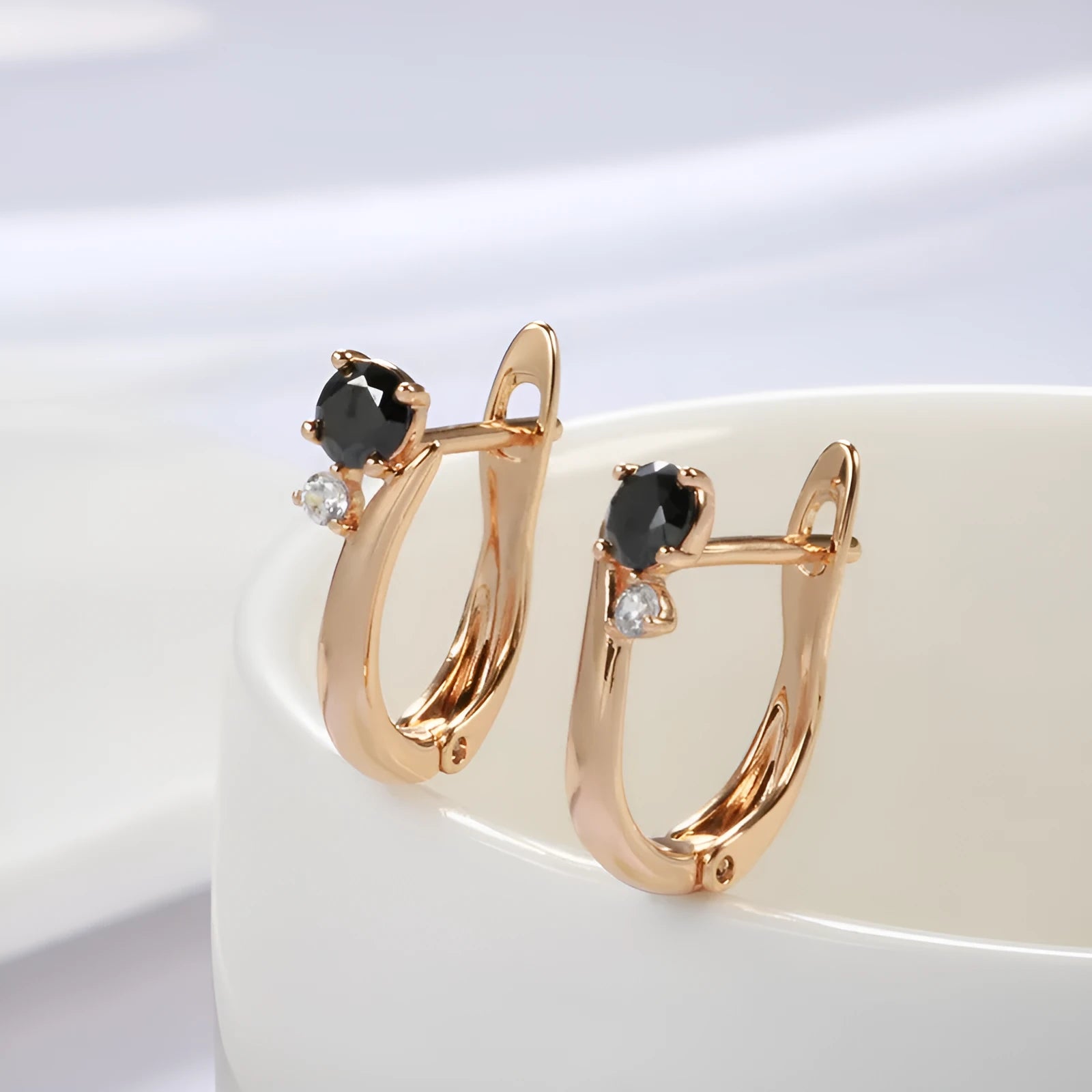 Gold coloured drop earrings with black agate stone centre and geometric design on copper settings