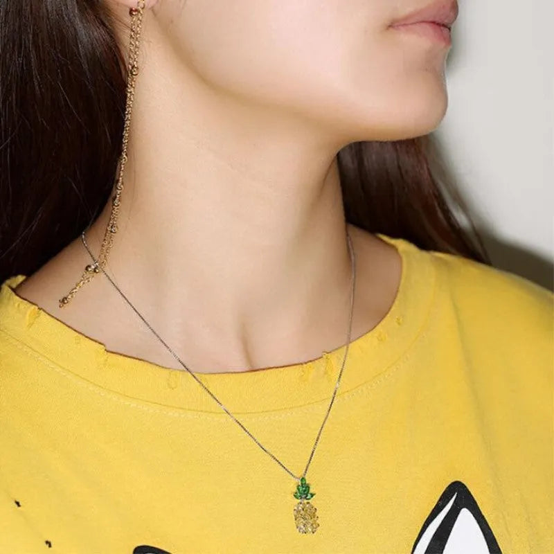 Silver women's necklace with a geometric pineapple and diamond design pendant on a chain.