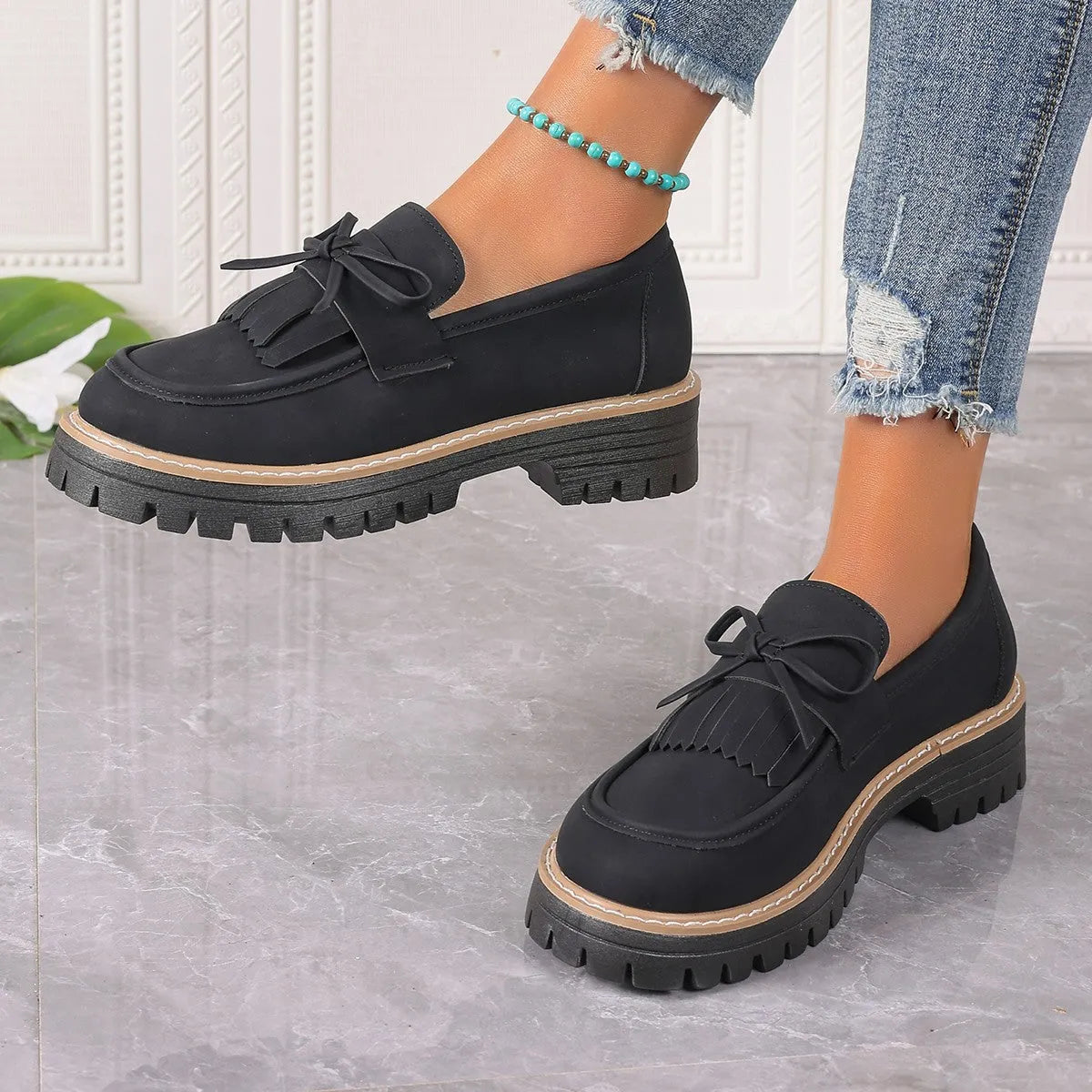 Black plus size women's loafer with tassel decoration and a bowknot on a low chunky heel.