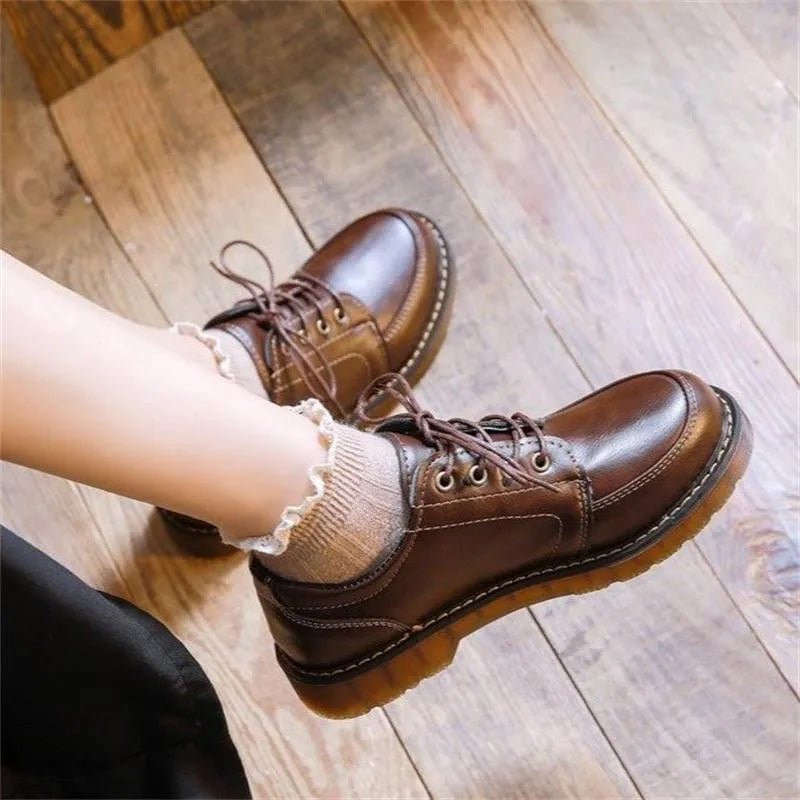 Women's black preppy style low-heel Mary Jane shoe with front lace-up and round toe on a white background.