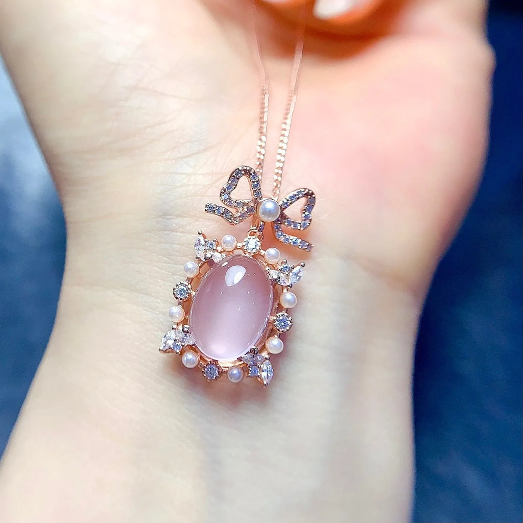 Geometric silver alloy pendant with pink rose quartz crystal and rose gold plating on a chain.