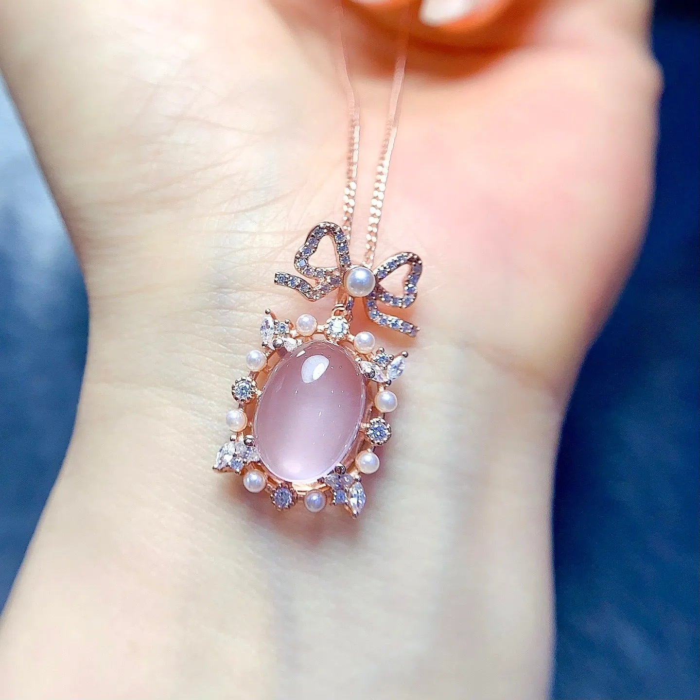 Geometric silver alloy pendant with pink rose quartz crystal and rose gold plating on a chain.